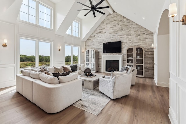 18252 Valleyview Cir, Clive, IA 50325 - living area with high vaulted ceiling, ceiling fan, beam ceiling, a large fireplace, and wood finished floors