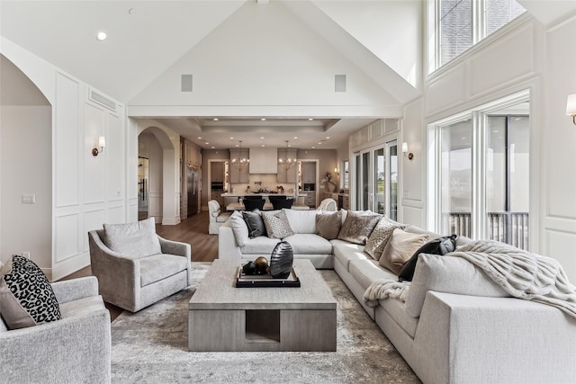 18252 Valleyview Cir, Clive, IA 50325 - living area featuring arched walkways, a chandelier, high vaulted ceiling, and wood finished floors