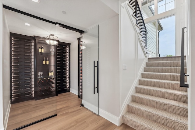 18252 Valleyview Cir, Clive, IA 50325 - wine area featuring baseboards, wood finished floors, plenty of natural light, and recessed lighting