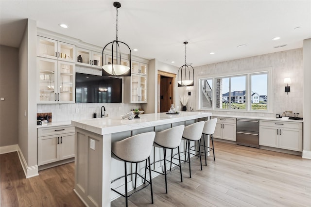 18252 Valleyview Cir, Clive, IA 50325 - kitchen featuring a center island, decorative backsplash, a breakfast bar, light wood finished floors, and recessed lighting