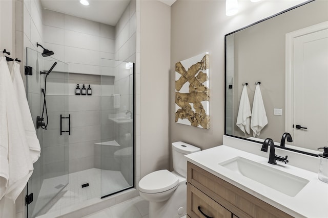 bathroom with tile patterned floors, a shower with door, vanity, and toilet