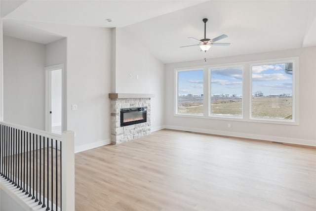 unfurnished living room with ceiling fan, light wood-type flooring, a fireplace, and vaulted ceiling