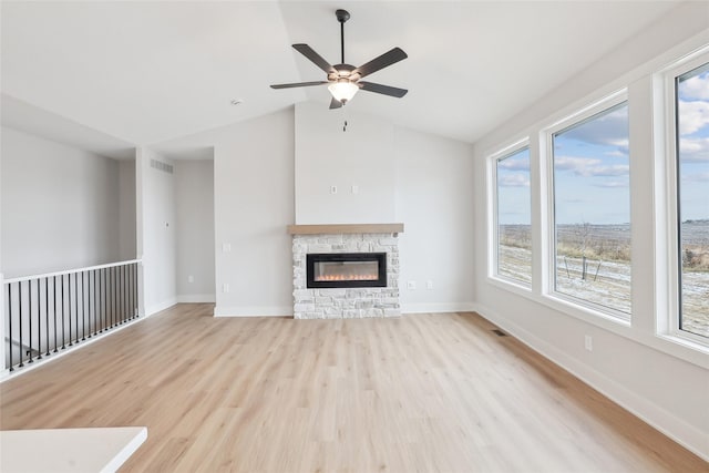 unfurnished living room featuring a fireplace, ceiling fan, light hardwood / wood-style flooring, and lofted ceiling