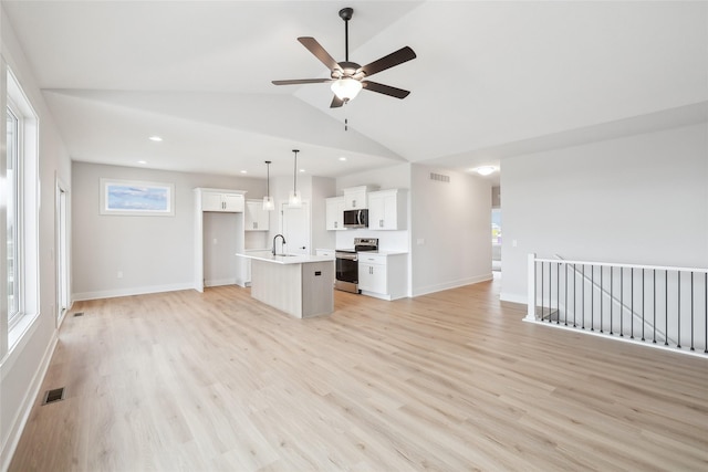 unfurnished living room featuring ceiling fan, light hardwood / wood-style floors, sink, and vaulted ceiling