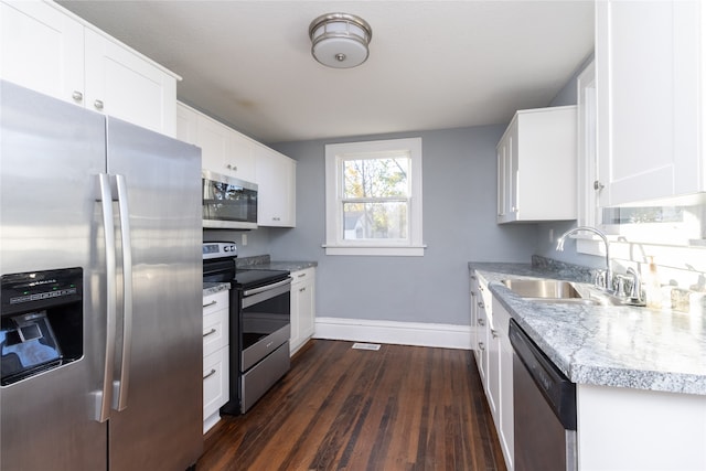 kitchen with stainless steel appliances, white cabinetry, sink, and dark hardwood / wood-style flooring