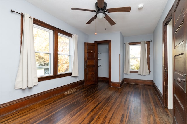 interior space featuring multiple windows, ceiling fan, and dark hardwood / wood-style floors