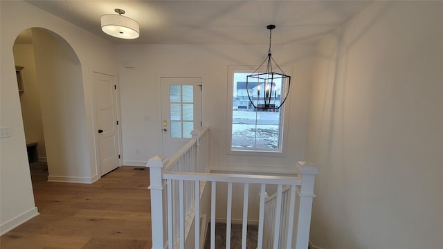 foyer entrance with light wood-type flooring and an inviting chandelier