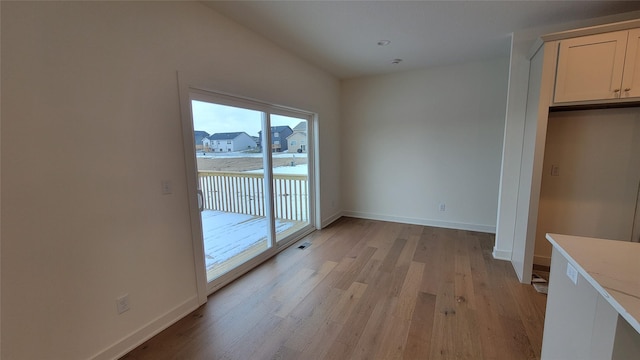 unfurnished dining area featuring light hardwood / wood-style floors and lofted ceiling