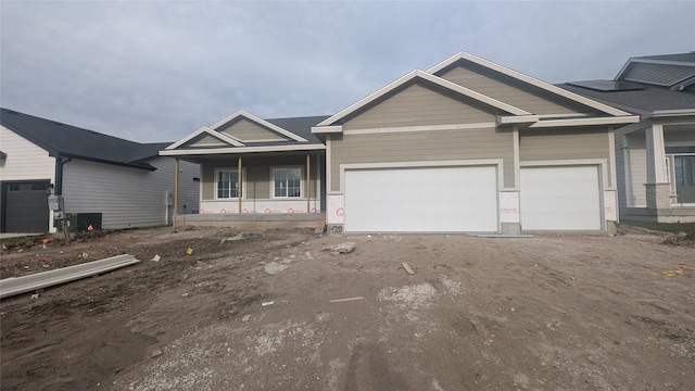 view of front of house with a porch, a garage, and cooling unit