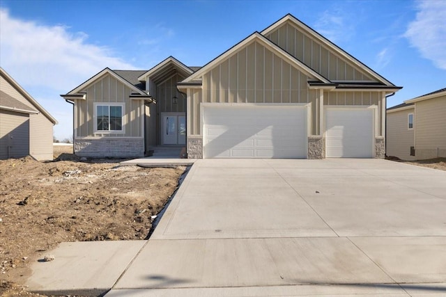 craftsman inspired home featuring board and batten siding, stone siding, driveway, and an attached garage