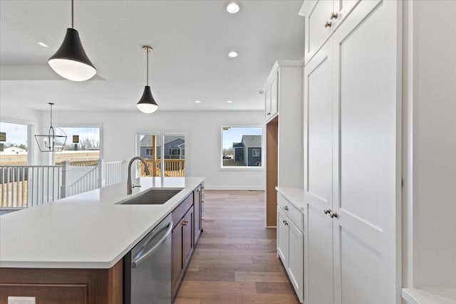 kitchen featuring sink, hanging light fixtures, a wealth of natural light, white cabinets, and stainless steel dishwasher