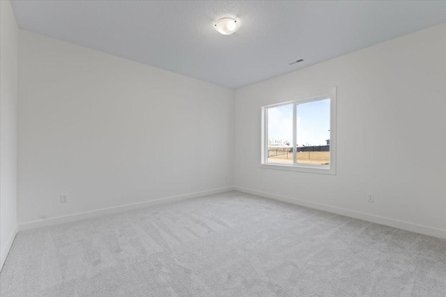 unfurnished room featuring light carpet and a textured ceiling