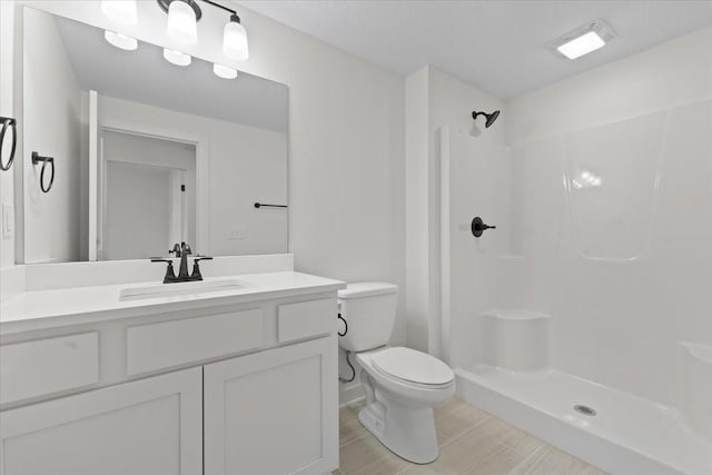 bathroom featuring a shower, vanity, a textured ceiling, and toilet