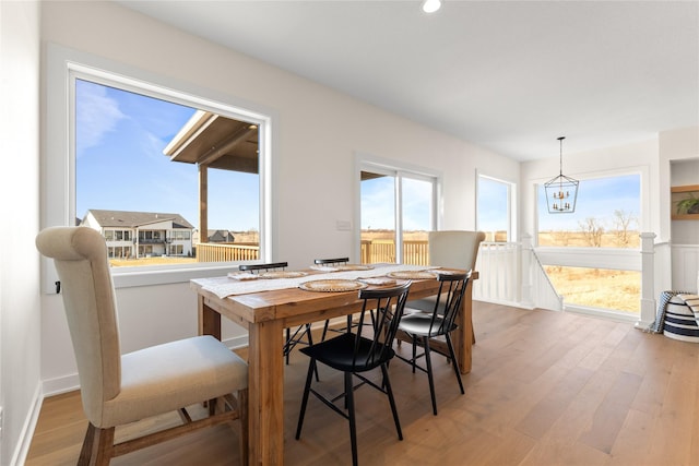 dining room featuring hardwood / wood-style floors, plenty of natural light, and a notable chandelier