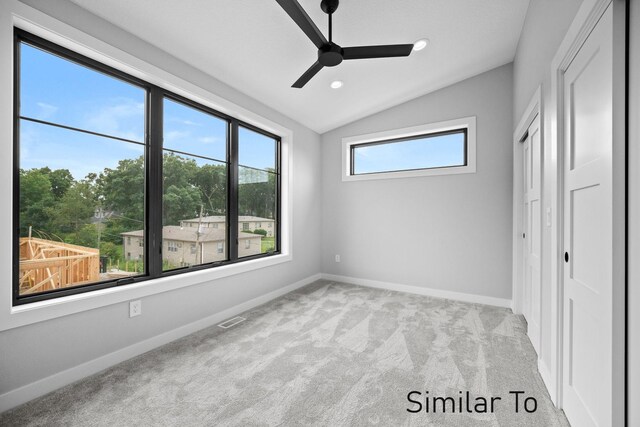 unfurnished bedroom featuring ceiling fan, light colored carpet, and vaulted ceiling