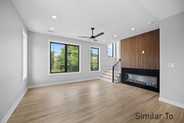 unfurnished living room featuring ceiling fan and light wood-type flooring