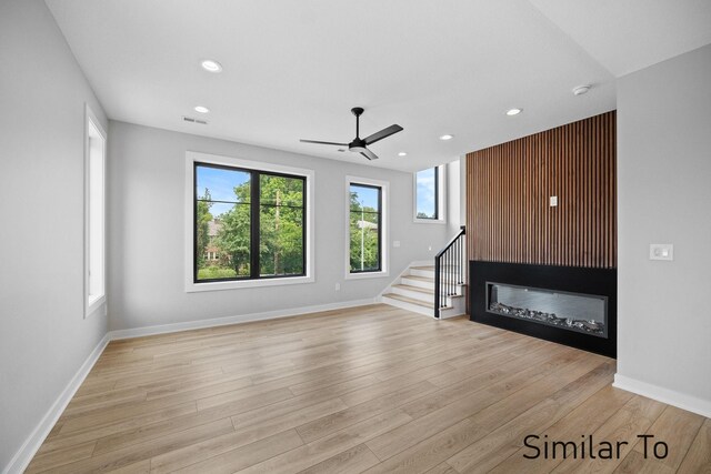 unfurnished living room featuring ceiling fan and light wood-type flooring