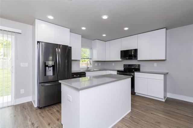 kitchen with white cabinets, a kitchen island, stainless steel appliances, and sink