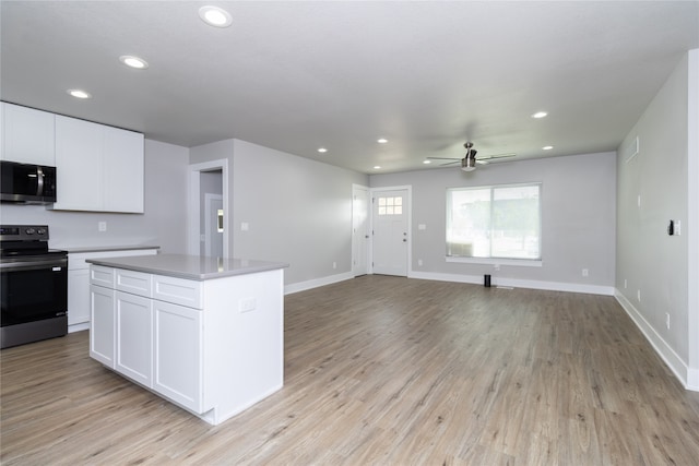 kitchen with a center island, light wood-type flooring, stainless steel appliances, white cabinetry, and ceiling fan