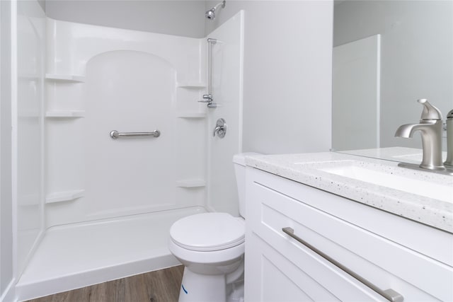 bathroom with vanity, toilet, wood-type flooring, and walk in shower