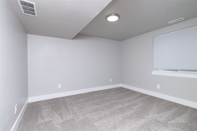 spare room featuring a textured ceiling and carpet floors