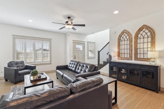 living room with ceiling fan and light hardwood / wood-style flooring