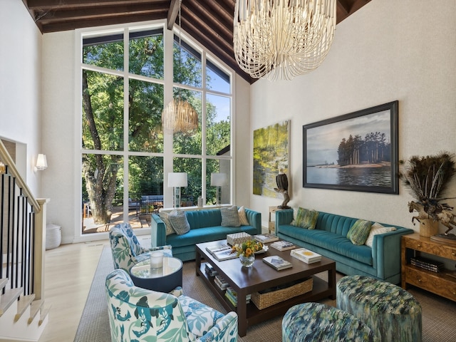 living room with hardwood / wood-style floors, high vaulted ceiling, and a notable chandelier