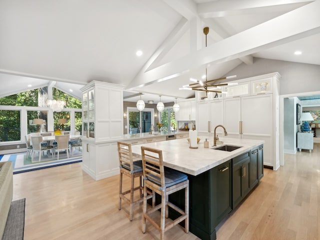 kitchen featuring vaulted ceiling with beams, an inviting chandelier, light hardwood / wood-style flooring, and a spacious island