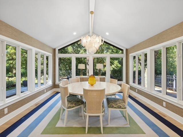 sunroom with lofted ceiling with beams and a notable chandelier