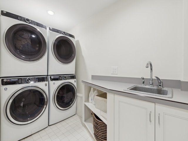 washroom with sink, light tile patterned floors, cabinets, and stacked washer and clothes dryer