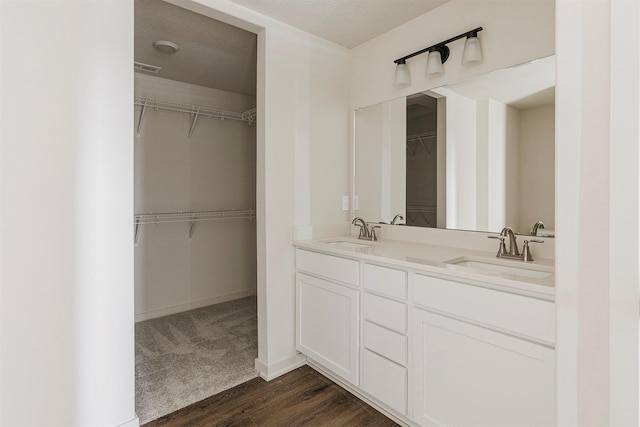 bathroom featuring a textured ceiling, vanity, and wood-type flooring