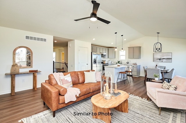 living room featuring hardwood / wood-style floors, lofted ceiling, and ceiling fan