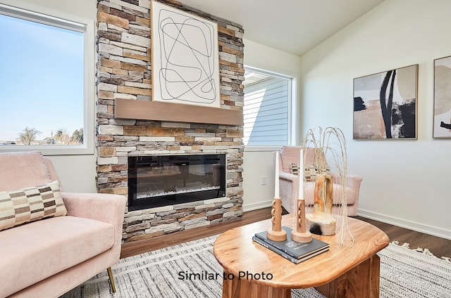 living room featuring hardwood / wood-style floors, a fireplace, and vaulted ceiling