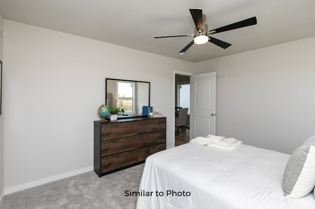 carpeted bedroom with a textured ceiling and ceiling fan