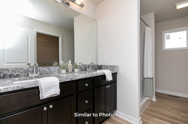 bathroom featuring walk in shower, vanity, and hardwood / wood-style floors