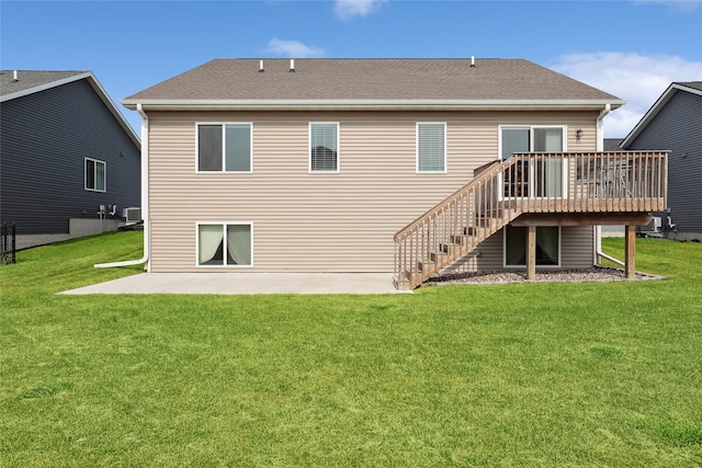 back of property with a wooden deck, a yard, and a patio