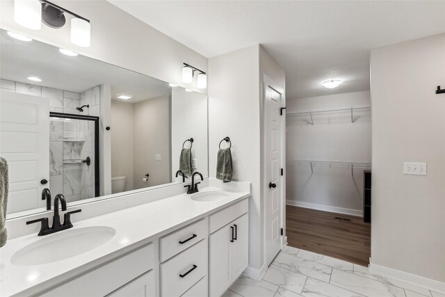 bathroom featuring walk in shower, vanity, and toilet