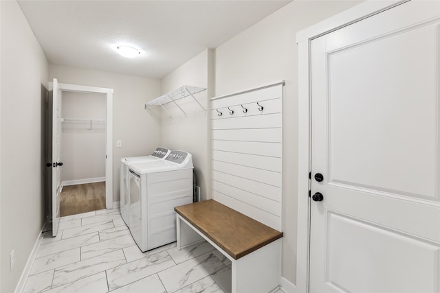 clothes washing area with a textured ceiling and separate washer and dryer