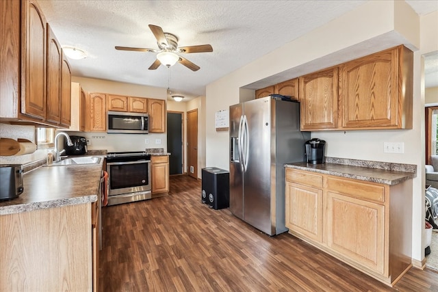 kitchen featuring stainless steel appliances, a textured ceiling, dark wood-type flooring, and sink