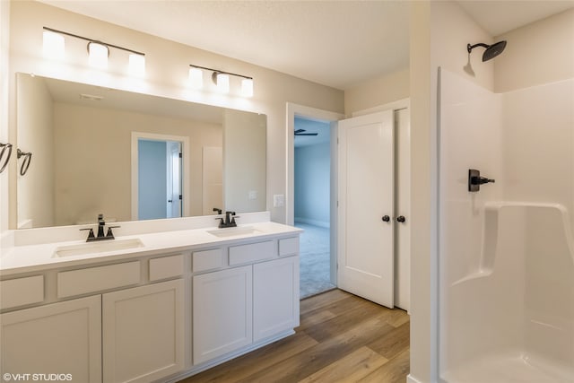 bathroom with wood-type flooring, vanity, and walk in shower