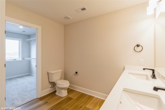 bathroom with hardwood / wood-style floors, vanity, and toilet