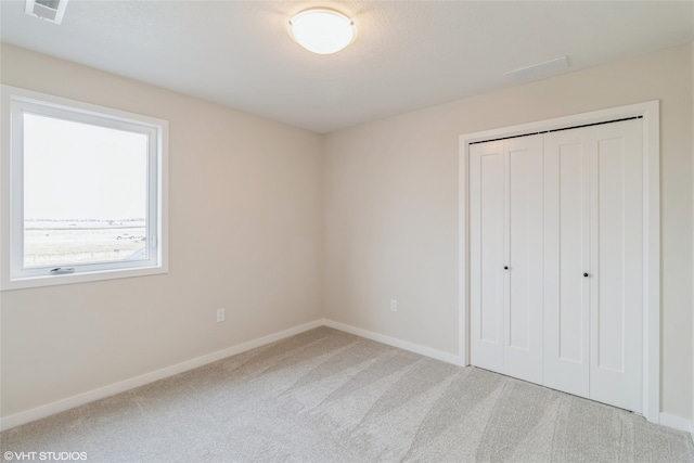 unfurnished bedroom featuring carpet floors and a closet