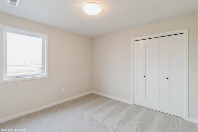 1109 Mulberry Dr NW, Bondurant, IA 50035 - unfurnished bedroom featuring a closet, visible vents, carpet flooring, and baseboards