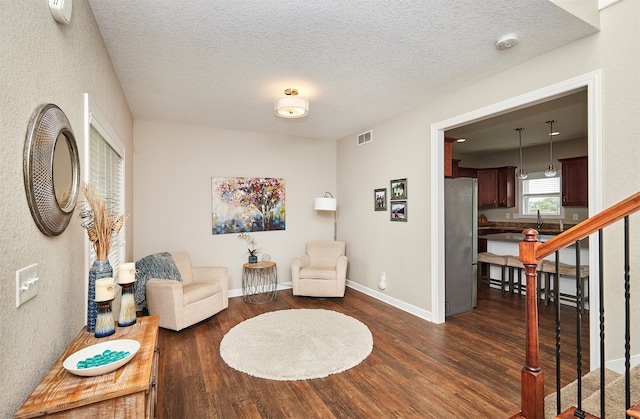 sitting room with a textured ceiling and dark hardwood / wood-style floors