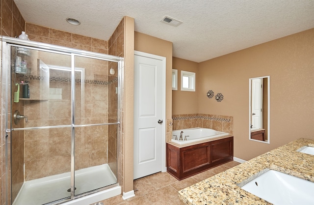 bathroom featuring tile patterned flooring, separate shower and tub, vanity, and a textured ceiling