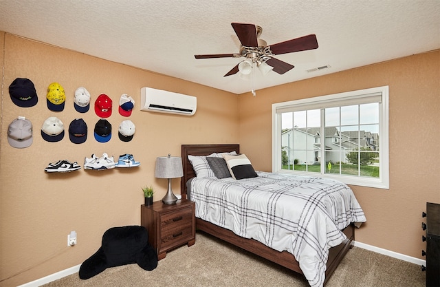 bedroom with a textured ceiling, ceiling fan, a wall unit AC, and carpet floors