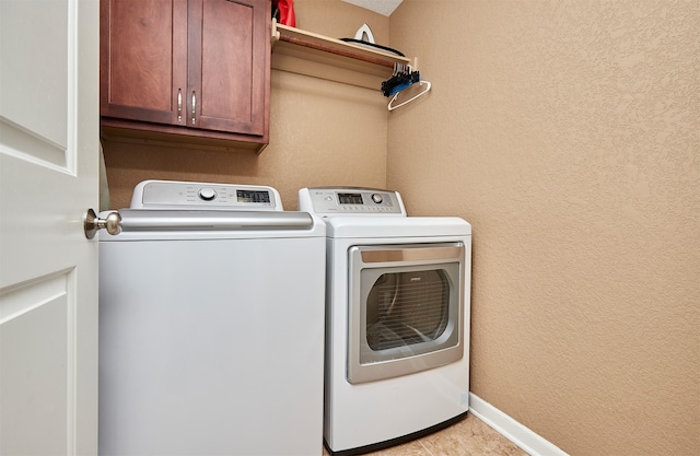 laundry room with cabinets and washer and dryer