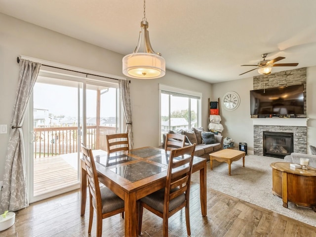 1401 S 10th St, Adel, IA 50003 - dining space featuring a ceiling fan, light wood-style flooring, and a stone fireplace