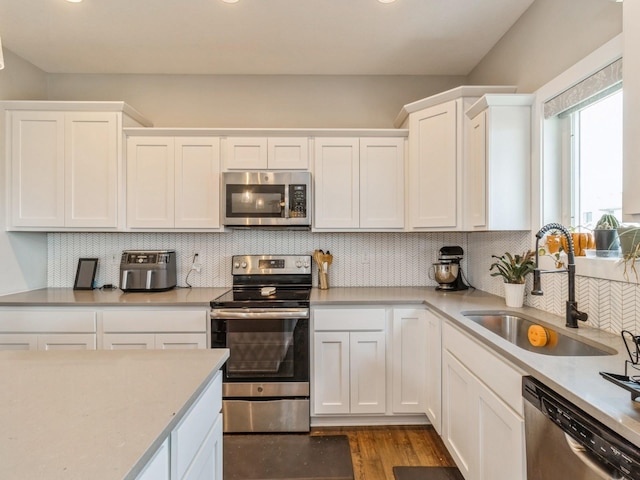 1401 S 10th St, Adel, IA 50003 - kitchen with appliances with stainless steel finishes, a sink, light countertops, and white cabinetry