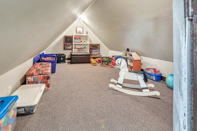 recreation room featuring vaulted ceiling, a textured ceiling, and carpet